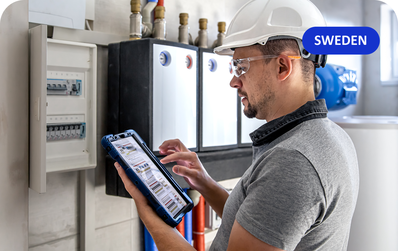 Technician using a tablet near HVAC controls